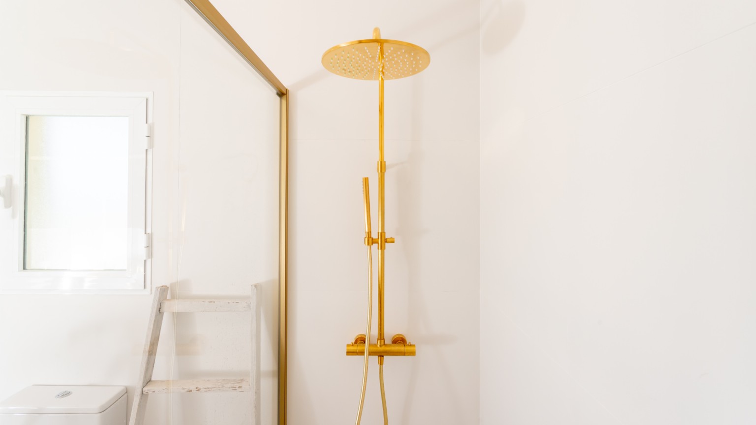 A guest bathroom with gold shower