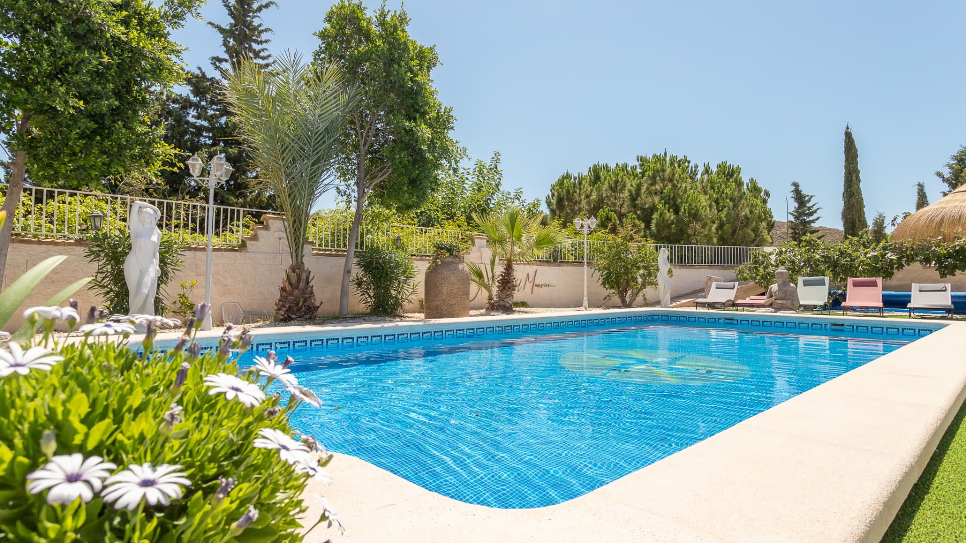 The pool terrace with sculpture and Mediterranean planting