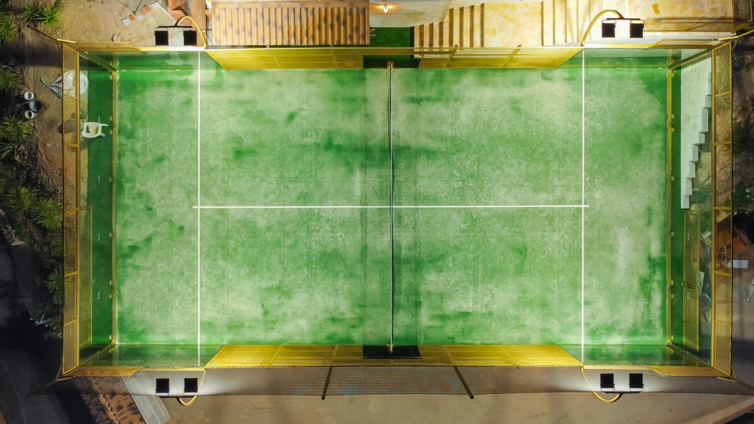 The lit padel court seen from directly above at night