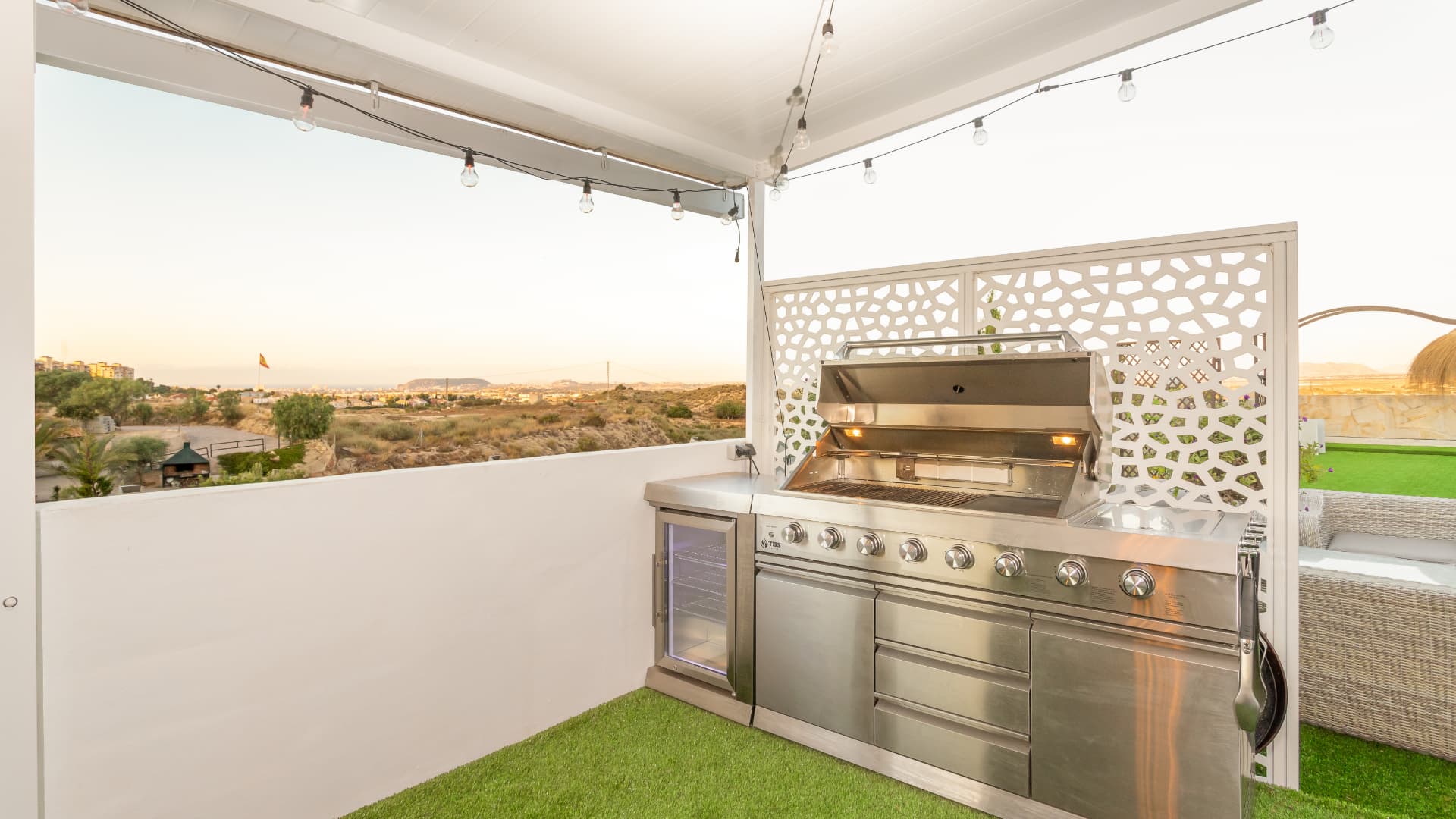 The outdoor kitchen with its grill and screened preparation wall